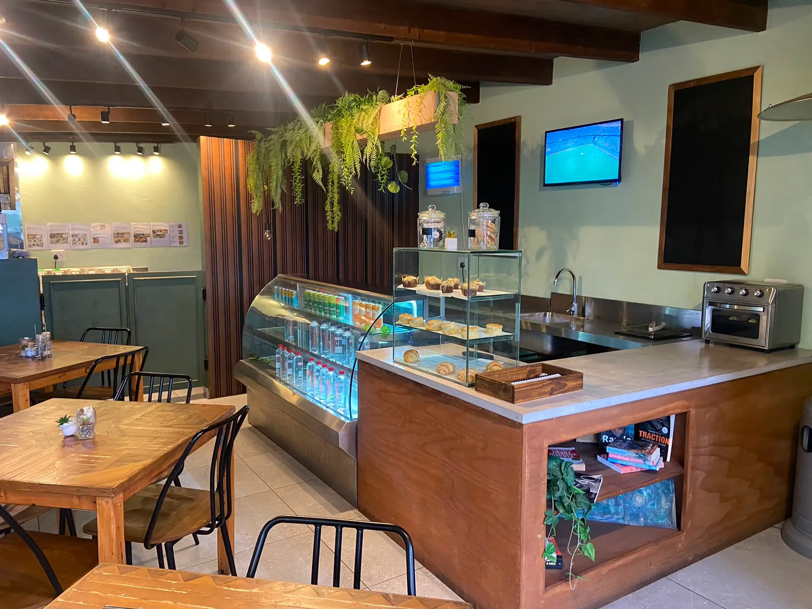 Meraki counter area with pastry case and plants