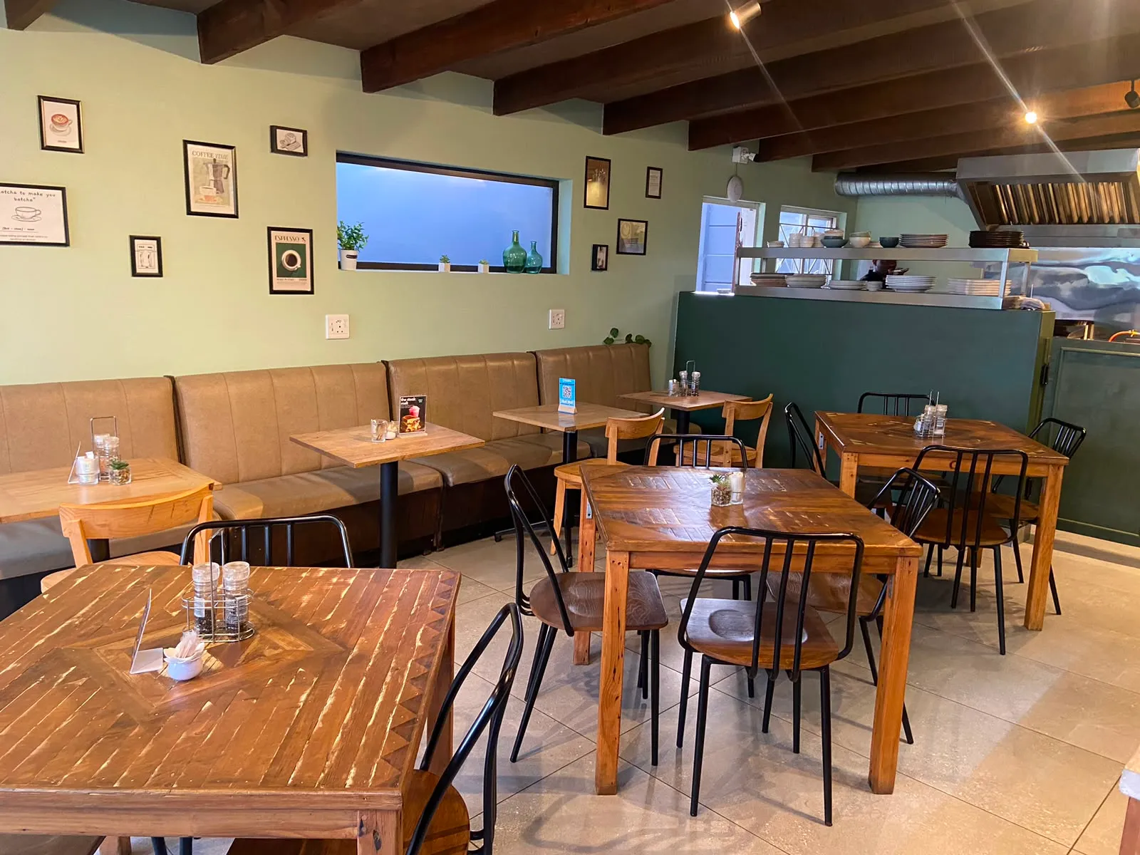 Warm Meraki Coffee House seating area with sage walls and wooden tables